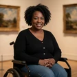 A Black woman in a wheelchair at an art gallery, an OpenHeartMatch community member