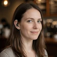 A woman with a hearing aid smiling in a coffee shop, an OpenHeartMatch community member